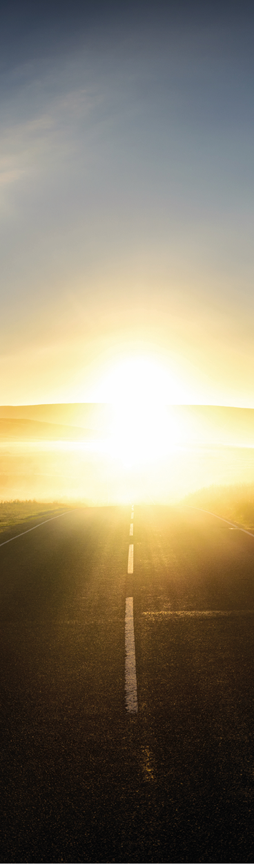 First sunlight reflecting from the mist on a road 
