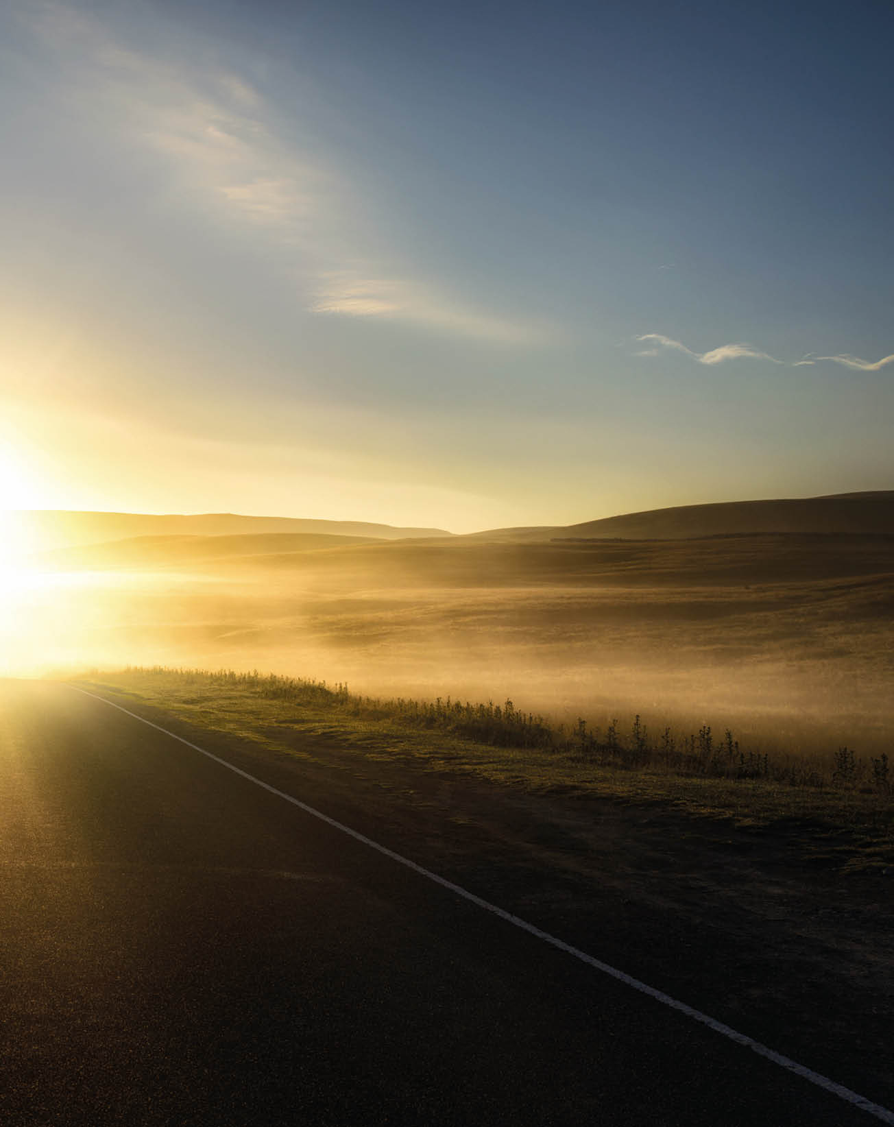 First sunlight reflecting from the mist on a road 