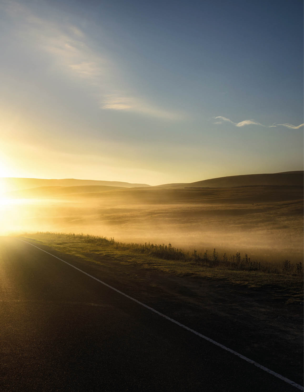 First sunlight reflecting from the mist on a road 