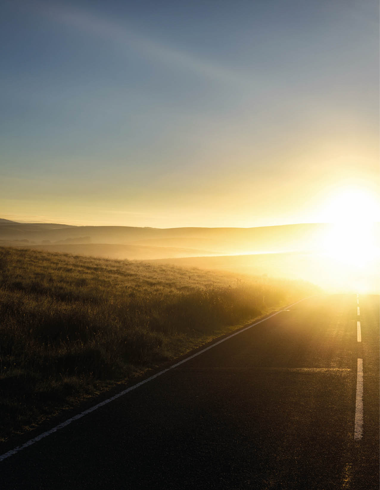 First sunlight reflecting from the mist on a road 